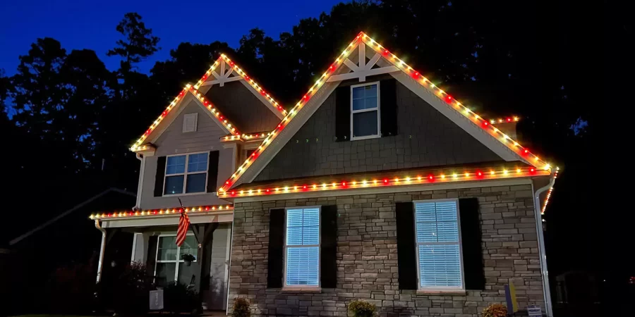 everlight-wiley2-6697ddf558785 Two-story house with red and yellow roofline lights, creating a warm and festive exterior lighting display at night.